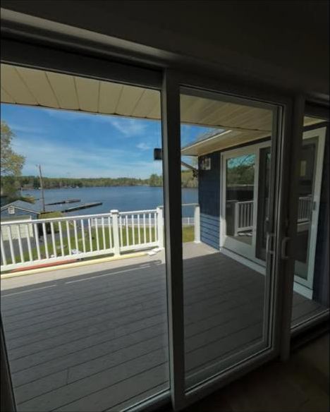 Clean sliding glass doors opening to a lakeside deck