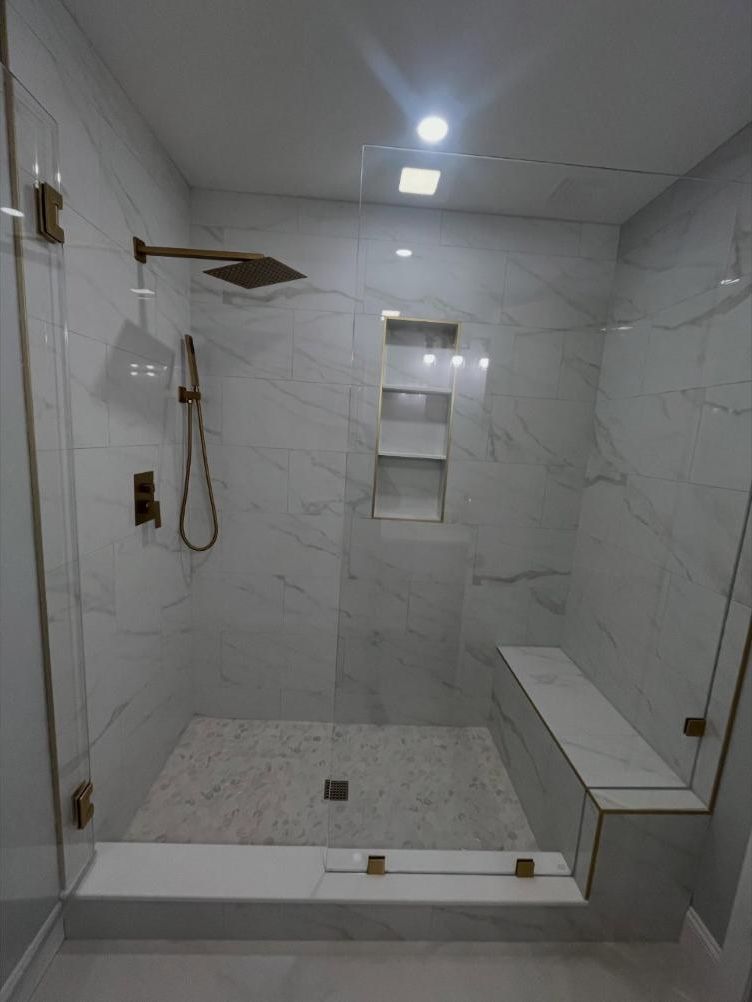 Marble-tile walk-in shower with gold fixtures